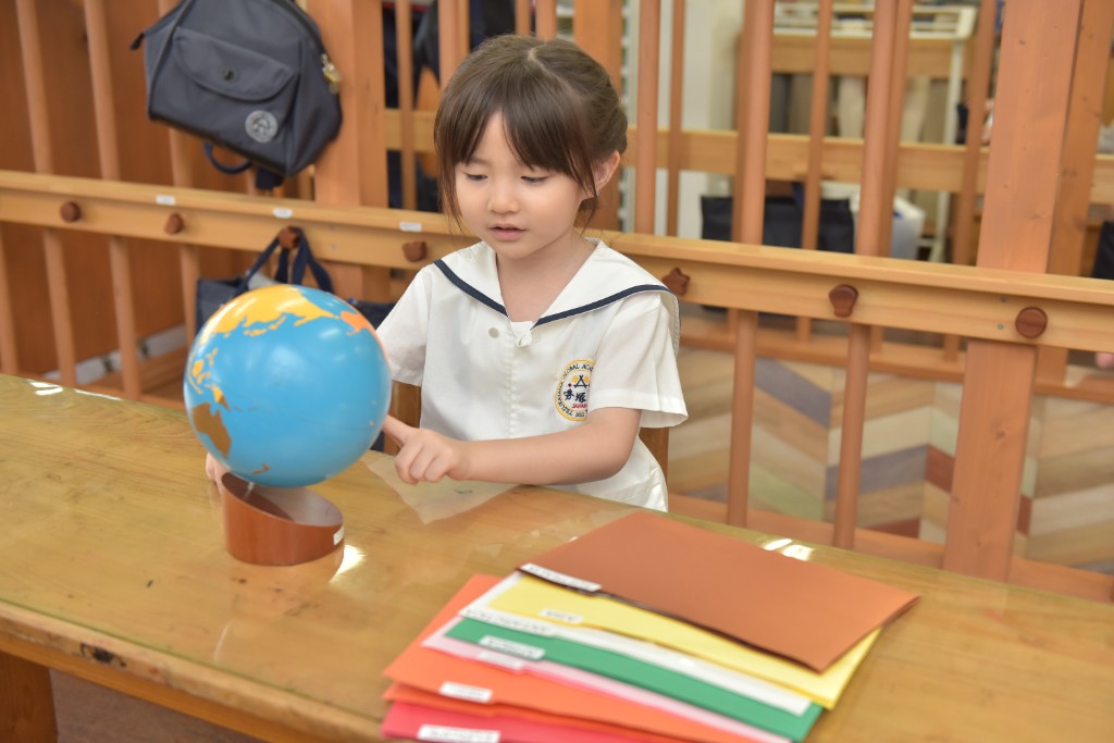 Student exploring a desk globe in the classroom