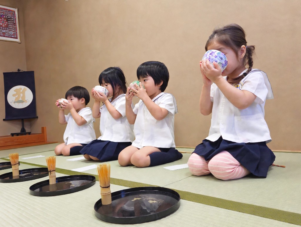 TGA students practising whisking matcha with an instructor during a tea ceremony lesson
